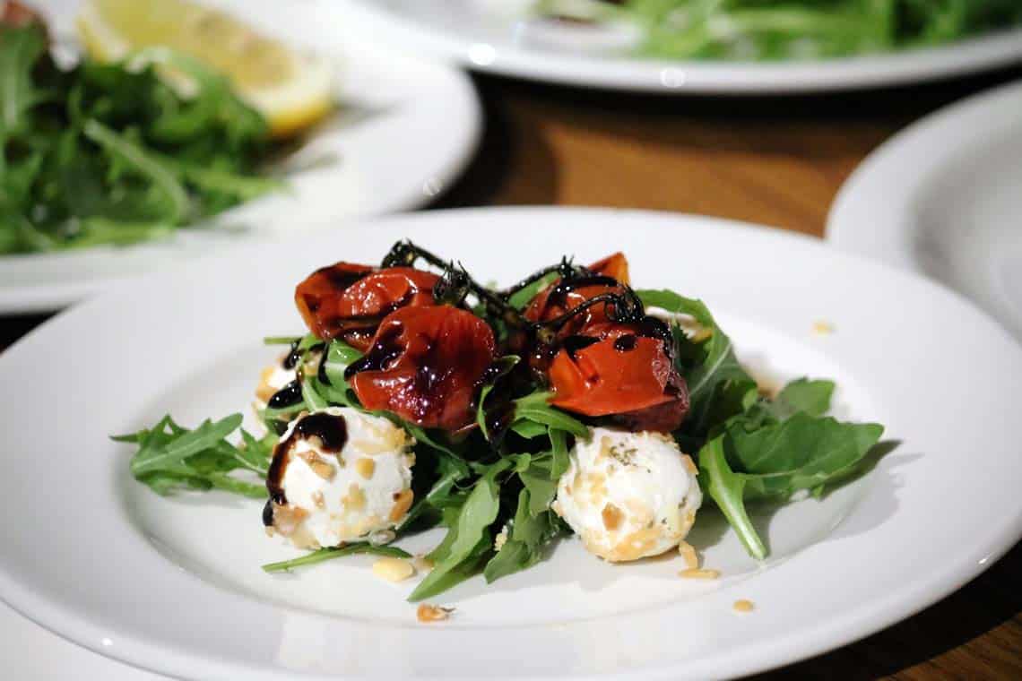 Almond Rolled Goats Cheese on Roquette, Roasted Cherry Tomatoes